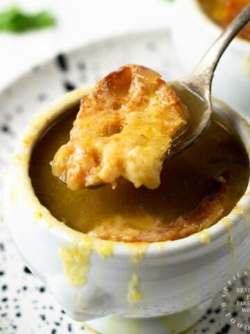 FRENCH ONION SOUP - a classic soup with deep caramelized onions in a beef broth topped with slice of toasted baguette and melty cheese #frenchonion #soup #wintersoups #cleaneating #happilyunprocessed