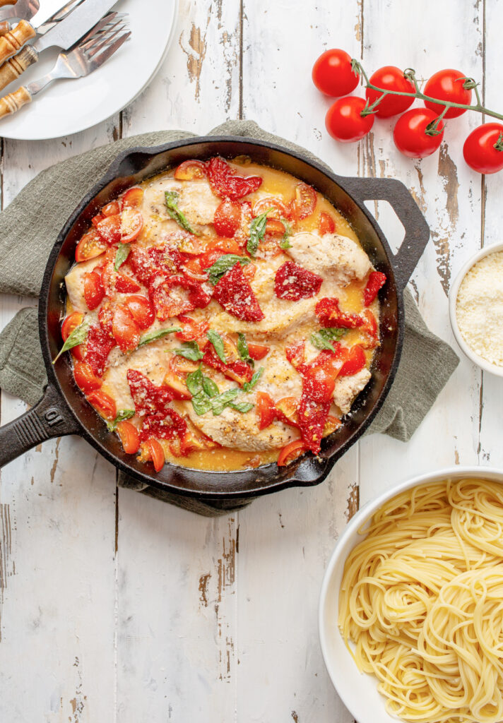 Tomato and Basil chicken in a garlic butter sauce in a cast iron skillet with sundried tomatoes
