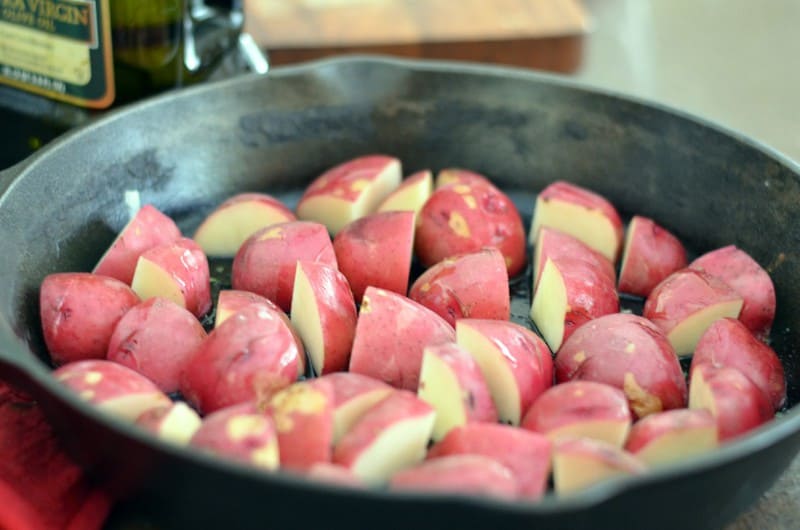 red potatoes in cast iron skillet ready to be roasted