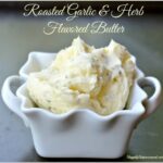 whipped light and airy roasted garlic and herb butter in small white dish