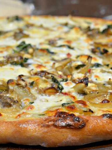 slice of caramelized onion, mushroom, feta pizza with white cream sauce