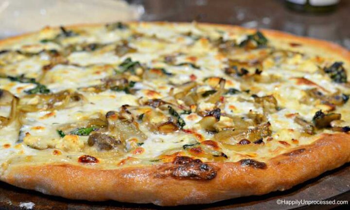 slice of caramelized onion, mushroom, feta pizza with white cream sauce