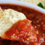 bowl of restaurant style salsa with tortilla chips slice of lime