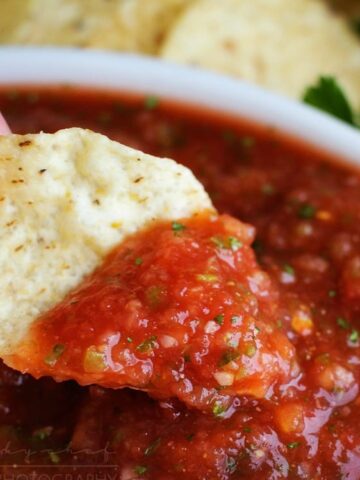 bowl of restaurant style salsa with tortilla chips slice of lime