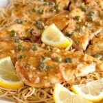 close up of chicken sauteed in a creamy lemony sauce topped with capers and parsley