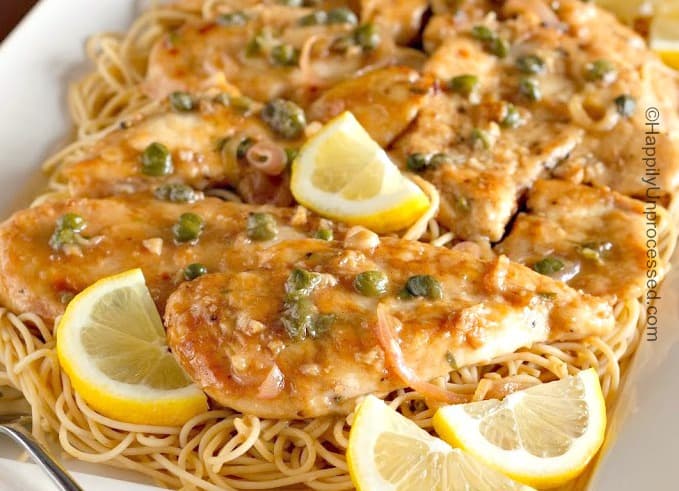 close up of chicken sauteed in a creamy lemony sauce topped with capers and parsley