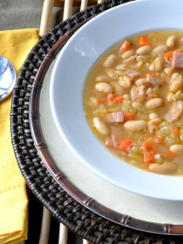 white bowl of white cannellini beans and ham soup