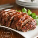 sliced meatloaf with honey whiskey bbq glaze on white plate
