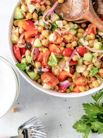 Mediterranean Chickpea and Feta Salad combined with a vinaigrette dressing in a bowl #chickpeasalad #summersalad #happilyunprocessed