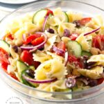 MEDITERRANEAN PASTA SALAD with bowtie pasta, red onion, cucumbers, cherry tomatoes, chick peas and feta cheese in a lemony vinaigrette #pastasalad #summer #sidedish #healthysidedish #happilyunprocessed