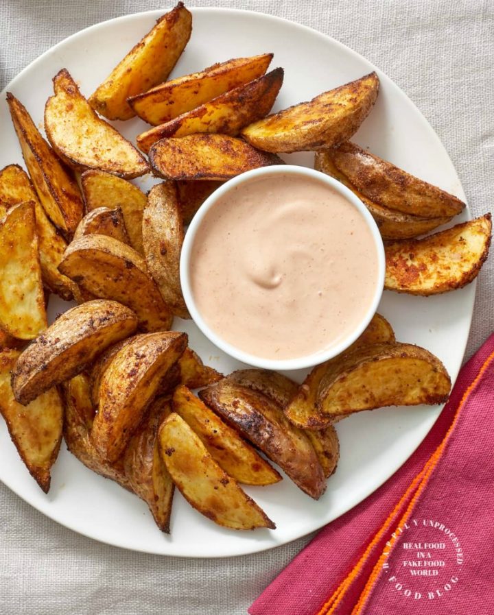 perfectly seasoned and roasted steak fries from Yukon Gold potatoes on a plate with dipping sauce