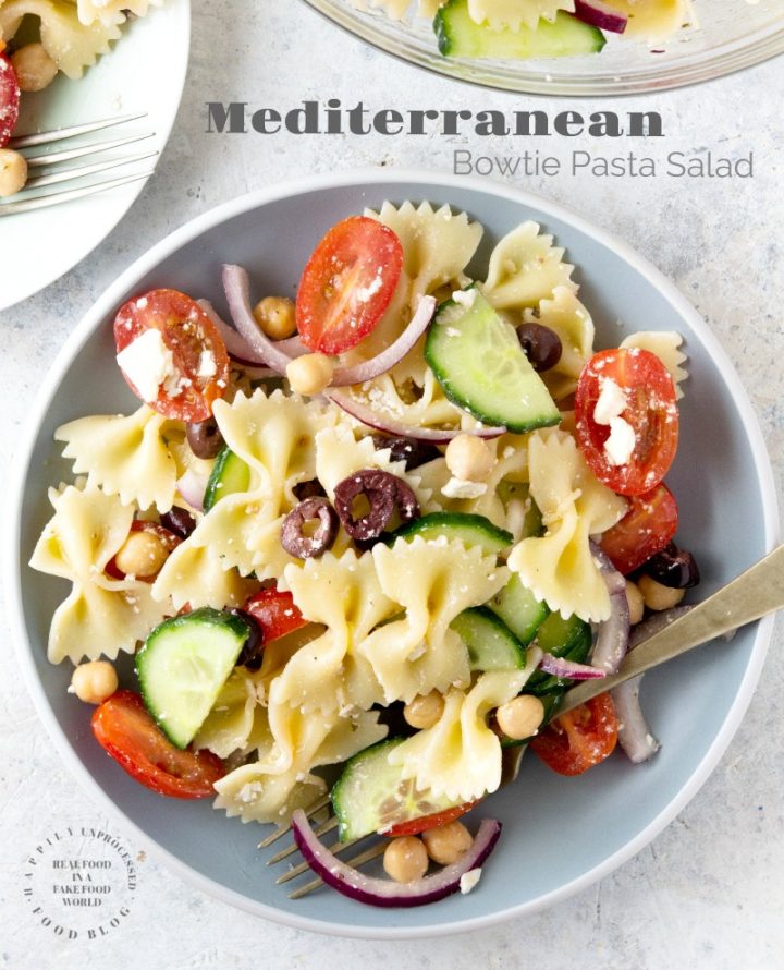MEDITERRANEAN PASTA SALAD with bowtie pasta, red onion, cucumbers, cherry tomatoes, chick peas and feta cheese in a lemony vinaigrette #pastasalad #summer #sidedish #healthysidedish #happilyunprocessed