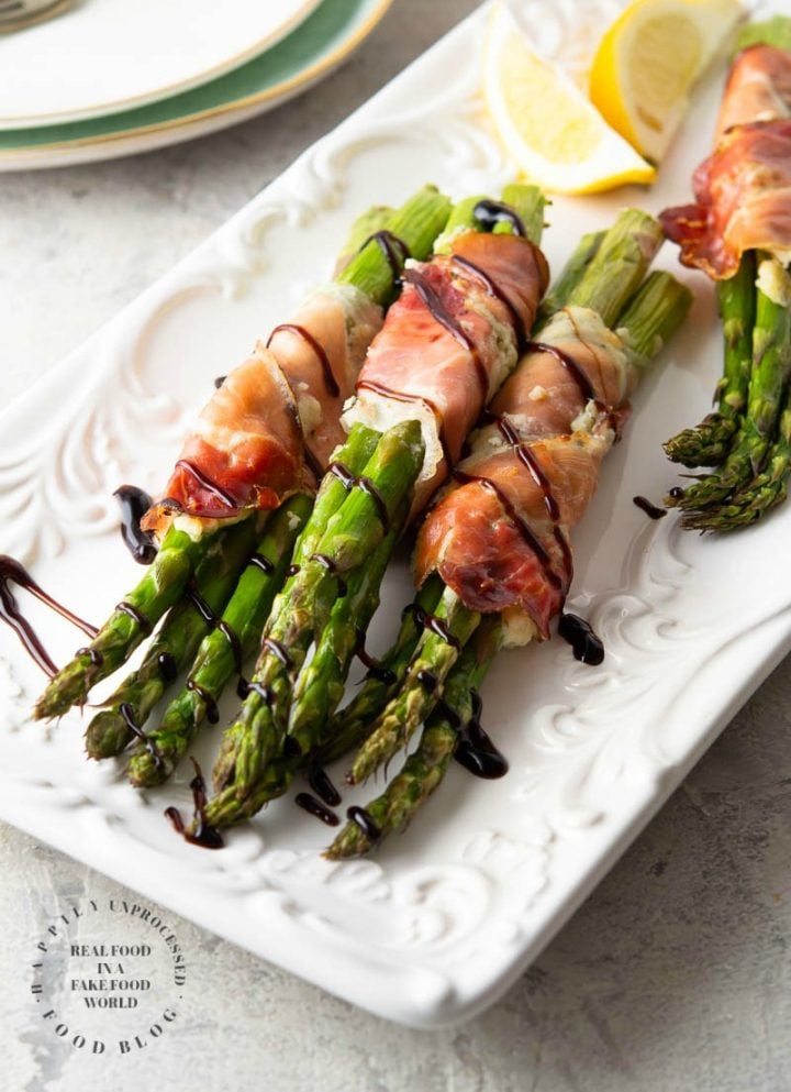 PROSCIUTTO WRAPPED ASPARAGUS - Garlic and Herb cheese is spread over prosciutto and then wrapped around fresh asparagus and baked until tender #asparagus #prosciutto #appetizer #happilyunprocessed