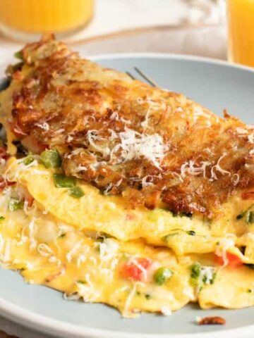 Hash Brown Wrapped Vegetarian Omelet - crispy golden hash browns form a perfect shell to wrap an omelet on the inside #breakfastfood #eggs #potatoes #hashbrowns #happilyunprocessed.com