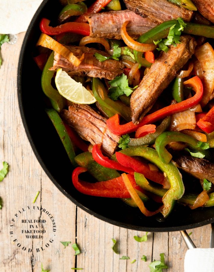 FLANK STEAK FAJITAS - perfectly grilled strips of flank steak with onions and peppers served with fresh tortillas, sour cream, guacamole and salsa #fajitas #happilyunprocessed