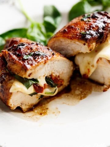 CAPRESE CHICKEN - Thin chicken breasts stuffed with sun dried tomatoes, mozzarella cheese topped with a sweet balsamic glaze #capresechicken #chicken #weeknightdinner #cleaneating #happilyunprocessed