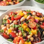 VIBRANT SUMMER 4 BEAN SALAD - 4 types of beans, colorful peppers, tomatoes, olives and red onion in a emulsified oil and vinegar dressing #summerrecipes #beansalad #potluck #healthy #summer #salads #happilyunprocessed