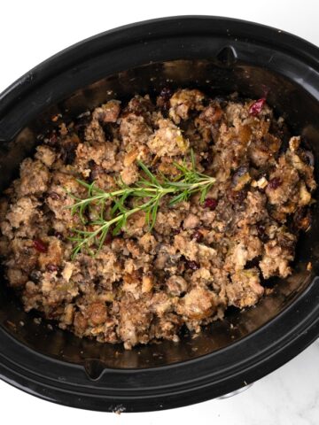 Slow cooker stuffing with sausage, cranberries, herbs and pecans. No turkey needed! The slow cooker makes the moistest best stuffing ever! #stuffing #thanksgiving #thanksgiving side dish # turkey #side dish