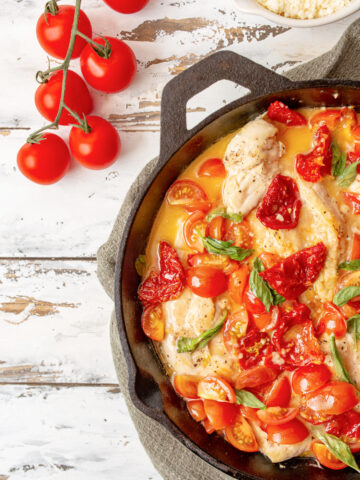 Tomato and Basil chicken in a garlic butter sauce in a cast iron skillet with sundried tomatoes