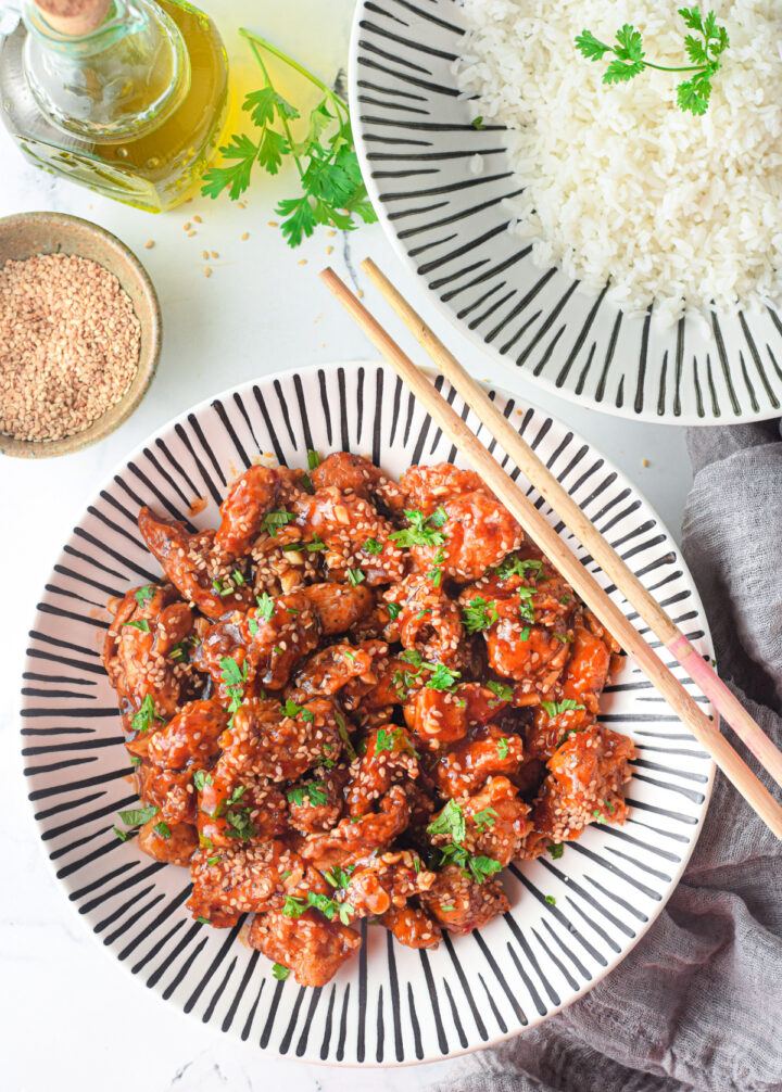 Air fryer sesame chicken with sesame seeds for garnish on a lovely plate