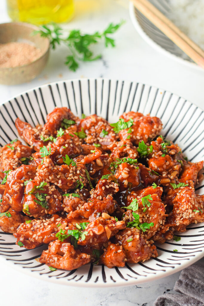 Sesame chicken made using the instant pot with sesame seeds on a plate
