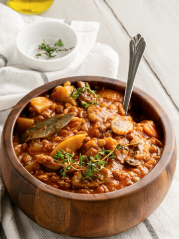 Vegetarian Lentil Mushroom Stew in a wooden earth toned bowl