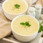 Healthy Potato Leek Soup in a white bowl with fresh parsley