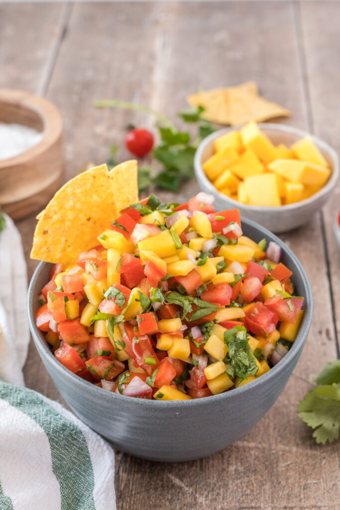 A big bowl of mango pico de gallo with tortilla chips is a healthy gluten-free vegan appetizer