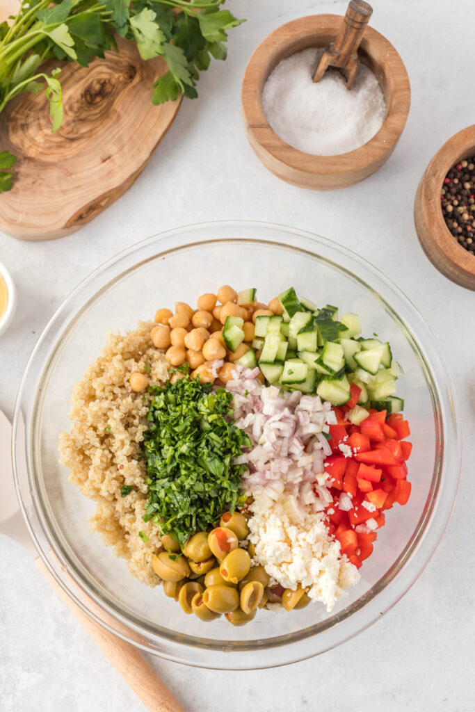 quinoa, chickpeas, red pepper, cucumbers and olives in a bowl for a healthy quinoa salad