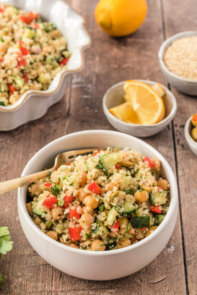 A bowl of quinoa salad with fresh cucumbers and olives