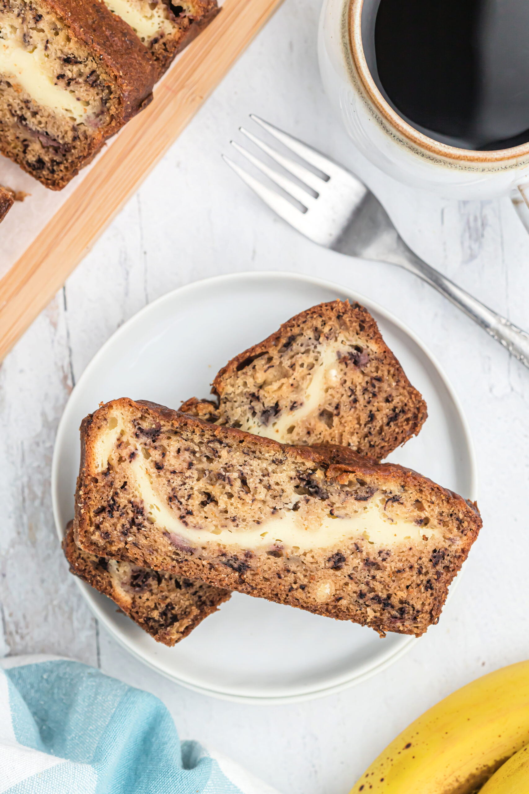 Slice of Banana bread with a cheesecake swirl and a cup of coffee
