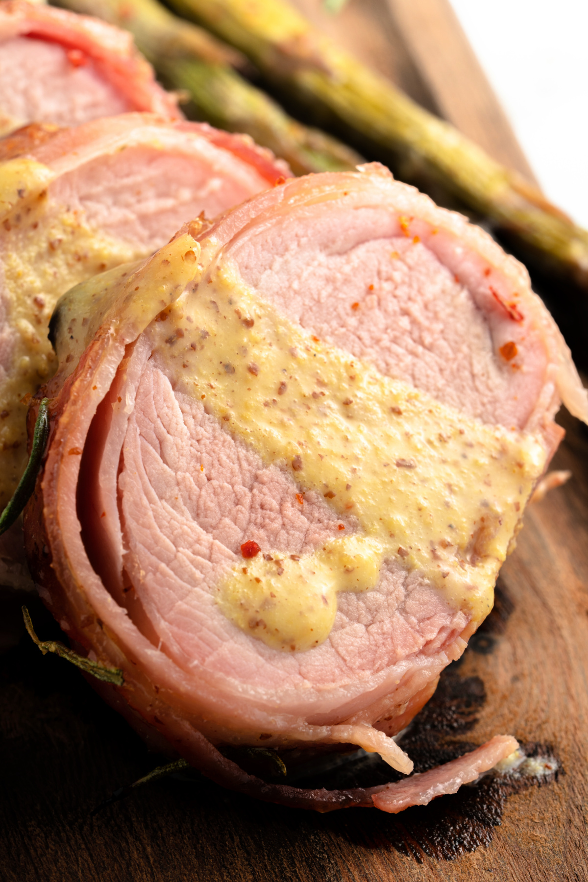 Bacon Wrapped Pork Tenderloin drizzled with honey Dijon sauce