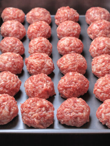 raw meatballs ready to be baked in the oven