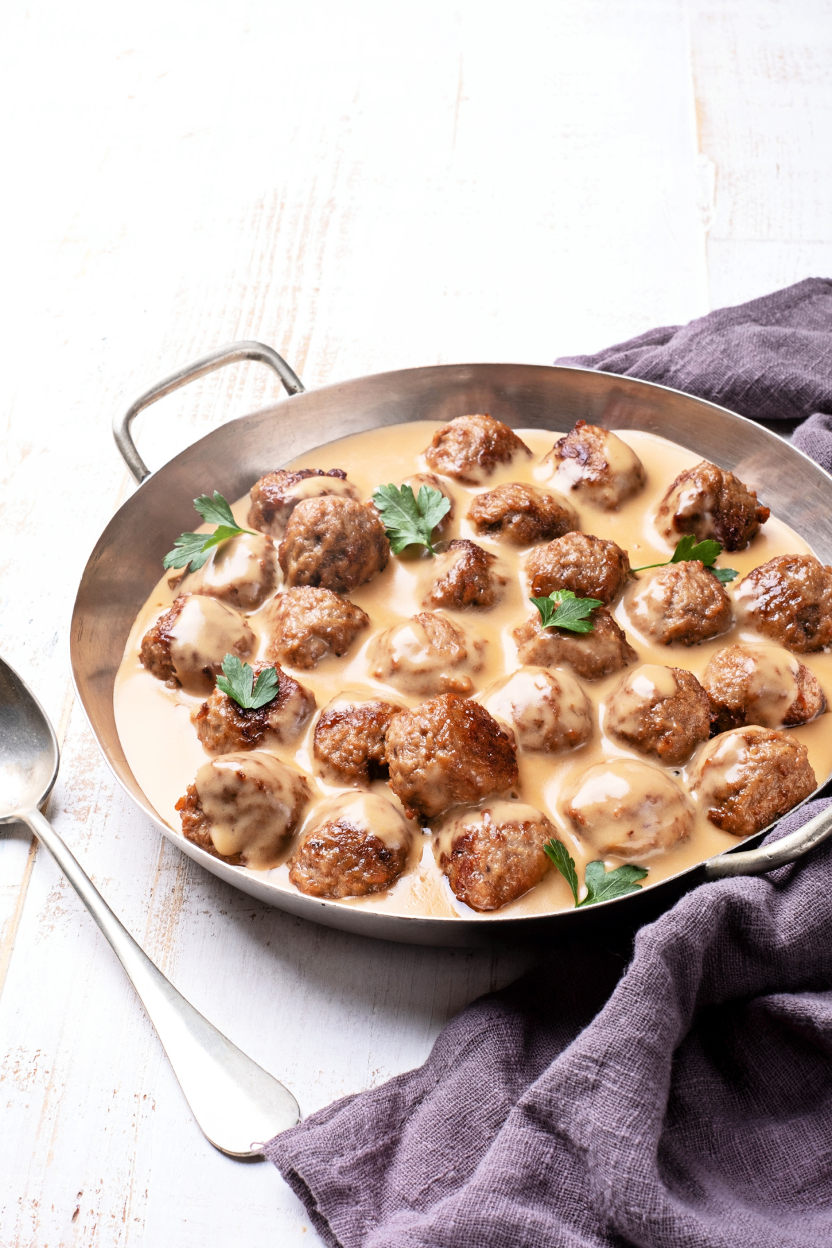 A pan of perfectly made Swedish meatballs in a cream sauce ready to be plated
