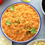 Homemade Yellow Mexican Rice in a blue bowl with fresh cilantro
