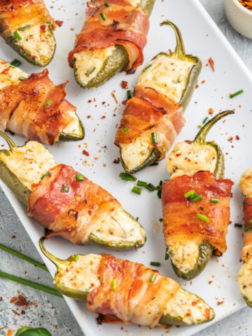 a-plate-of-garlic-and-chive-herbed-cream-cheese-jalapeno-poppers-wrapped-in-bacon-on-a-plate-