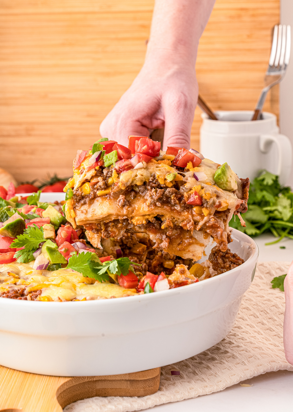 Layered Mexican Taco Lasagna Casserole with ground beef, beans, tomatoes and cheese, sour cream and lettuce