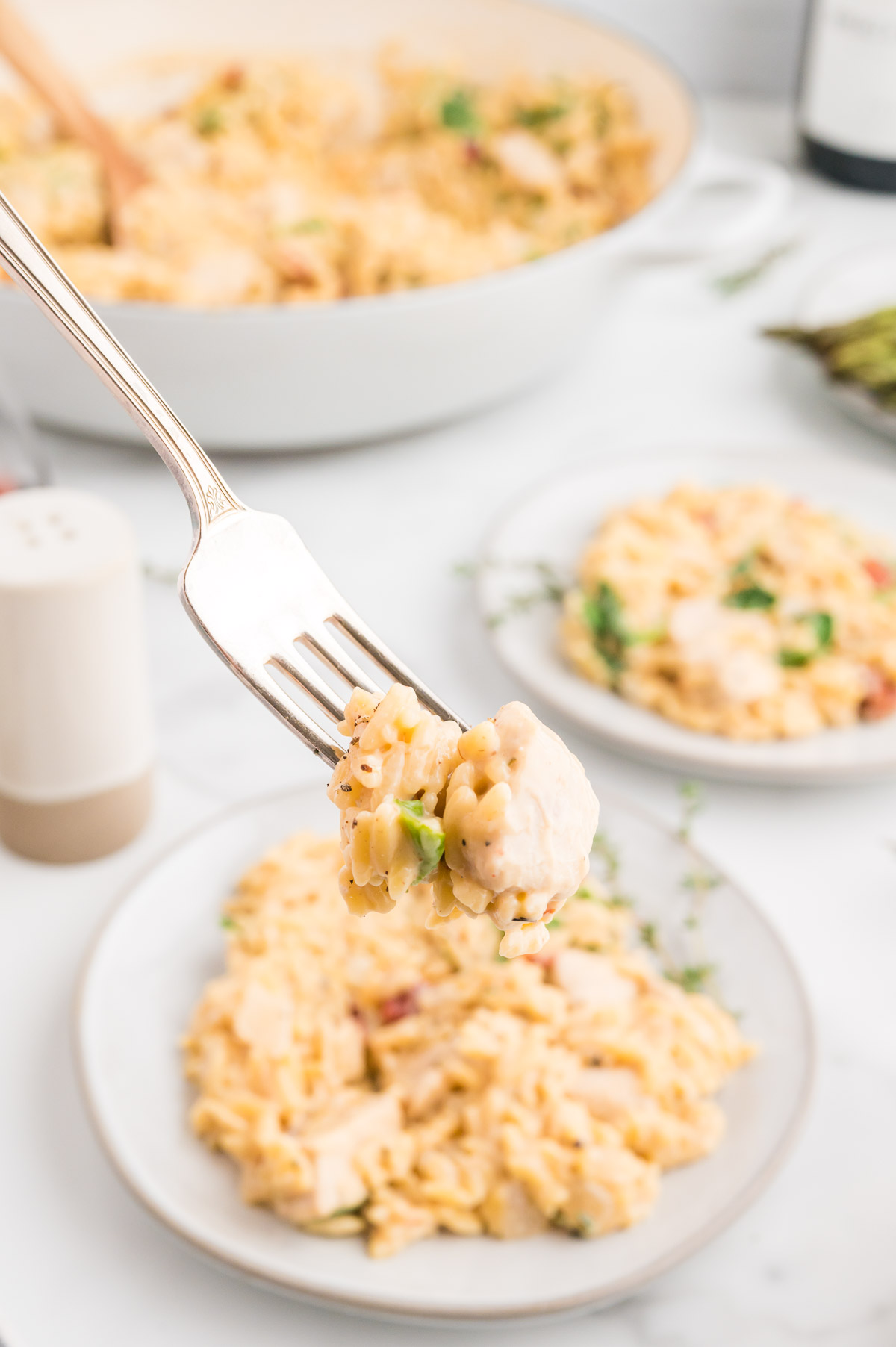 A bite of creamy Parmesan orzo chicken spinach and sun dried tomatoes