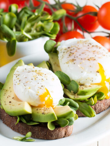 a perfectly poached egg with fresh avocado on toast