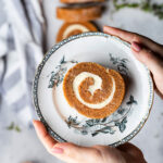 A slice of perfectly made pumpkin roll with a cream cheese filling