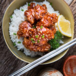 sesame chicken over rice in a bowl