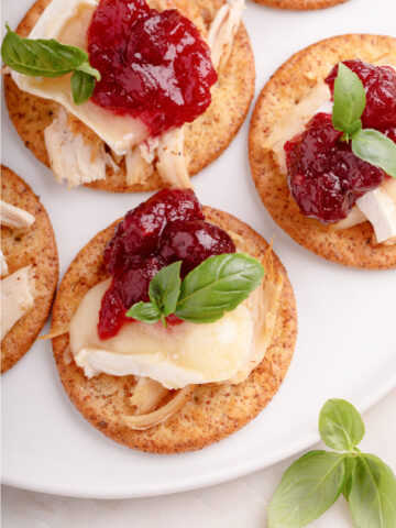 Leftover Thanksgiving turkey, brie and cranberry sauce on crackers
