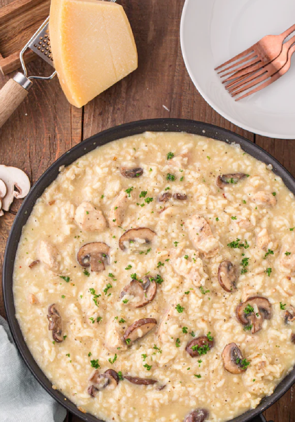 Large skillet of mushroom risotto with chunks of chicken