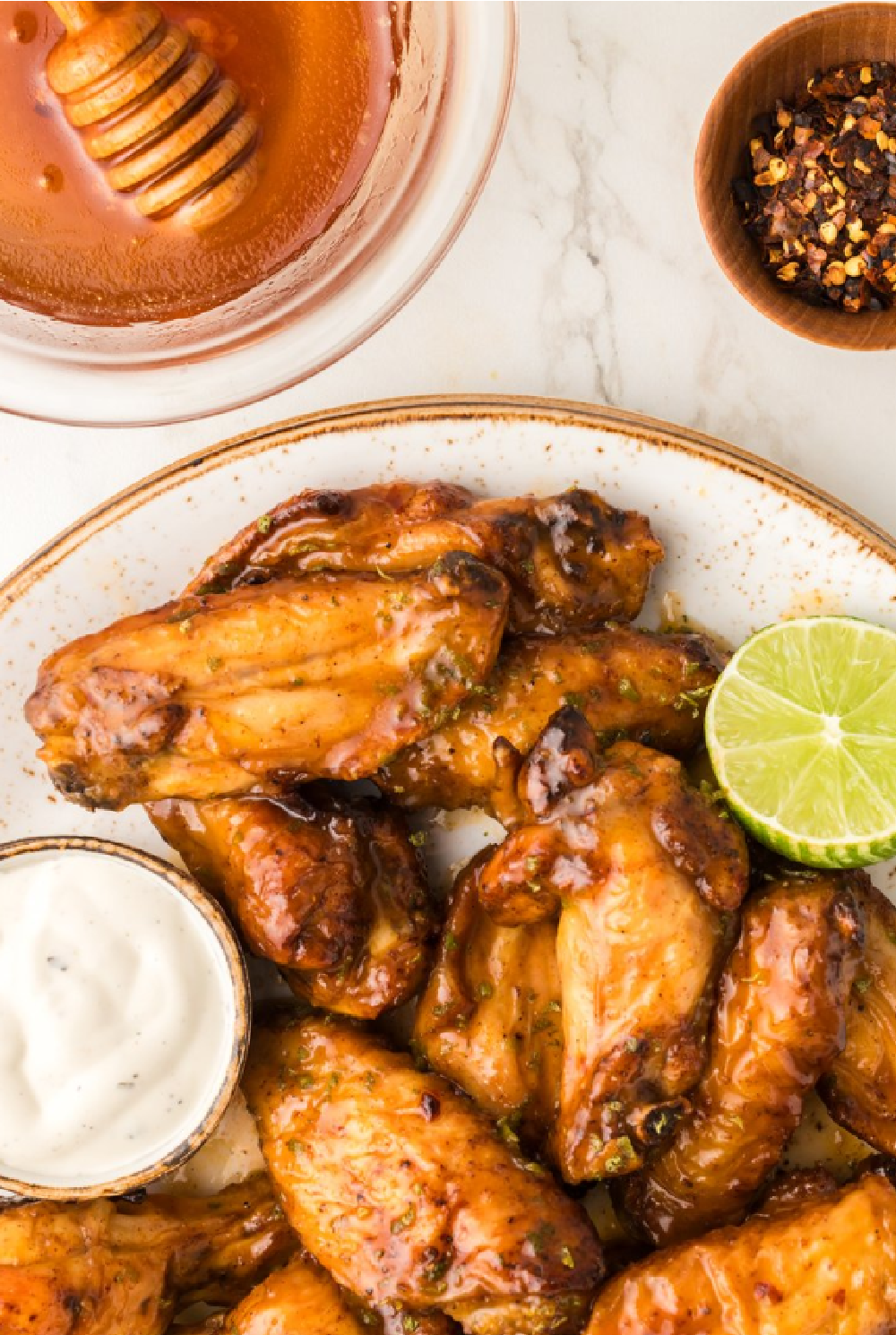 a plate of hot grilled chicken wings and drumsticks with a dry rub and honey lime glaze brushed on