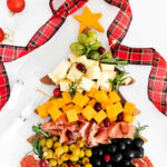 a holiday Christmas tree board with cheese, olives and nuts