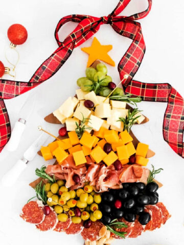 a holiday Christmas tree board with cheese, olives and nuts