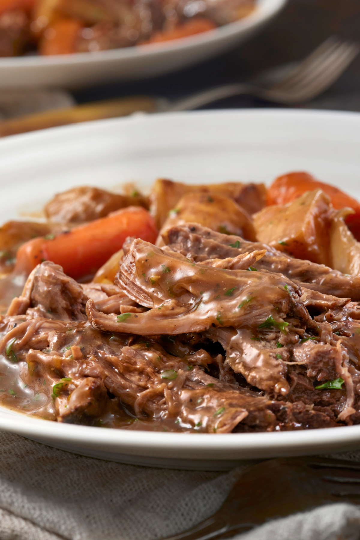 Perfectly cooked pot roast with carrots, celery, mushrooms and potatoes using the slow cooker